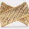 t Woven gold clutch bag on a light background